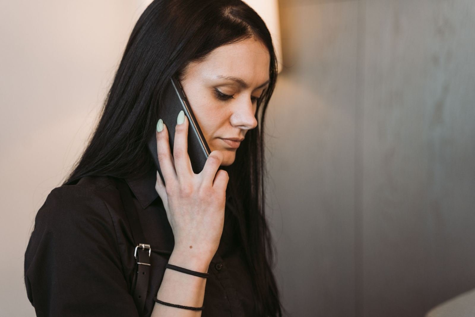 A woman with long dark hair talking on a smartphone