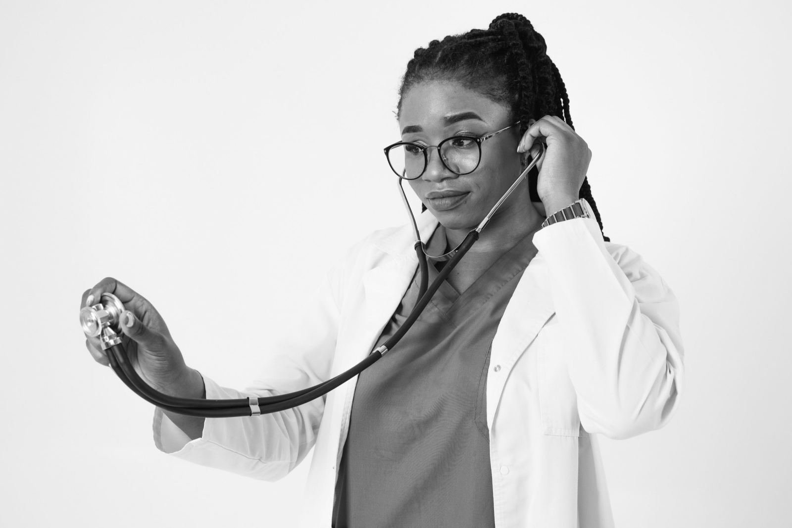 A healthcare professional in a white coat using a stethoscope