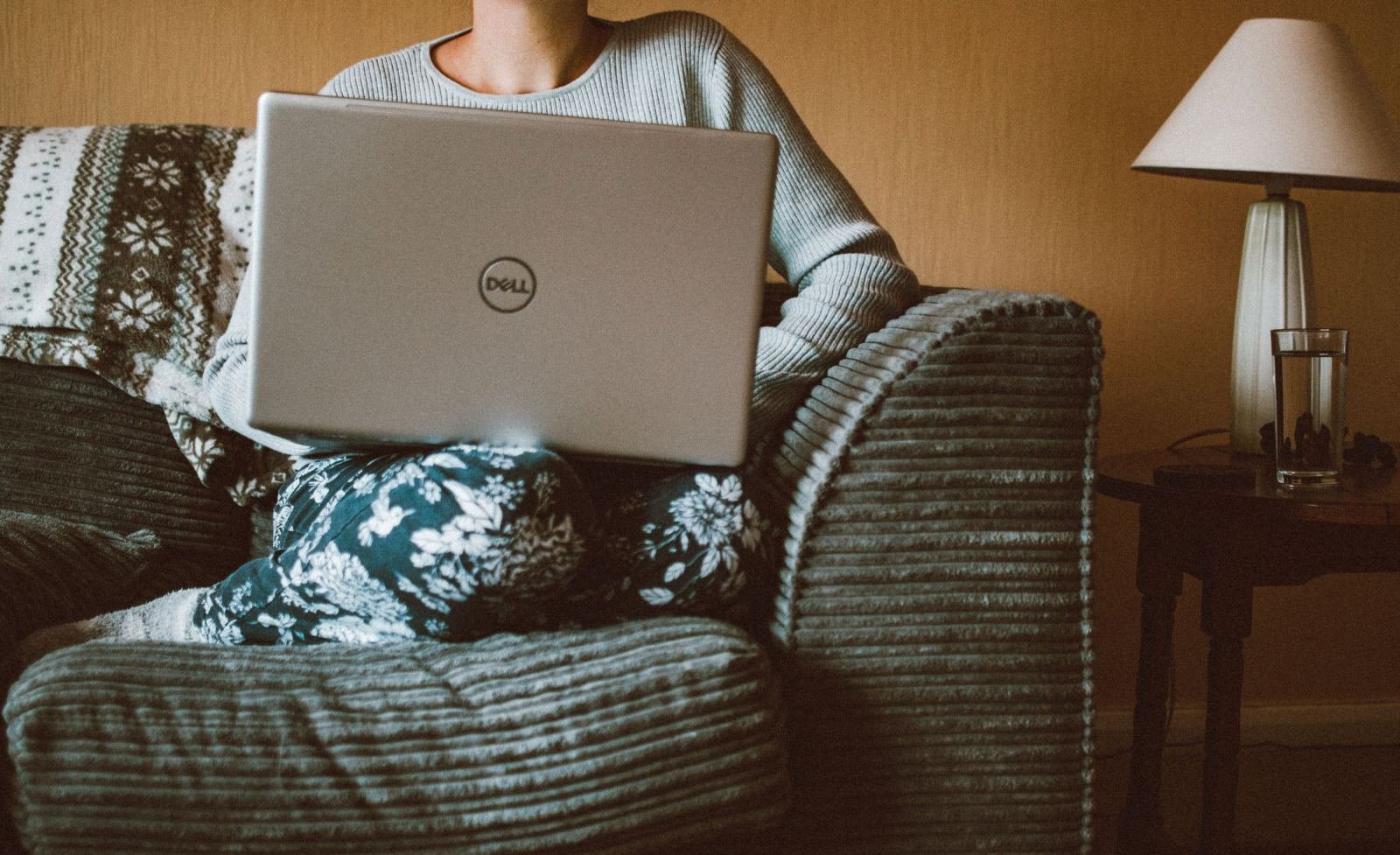 A person sitting in an armchair using a laptop