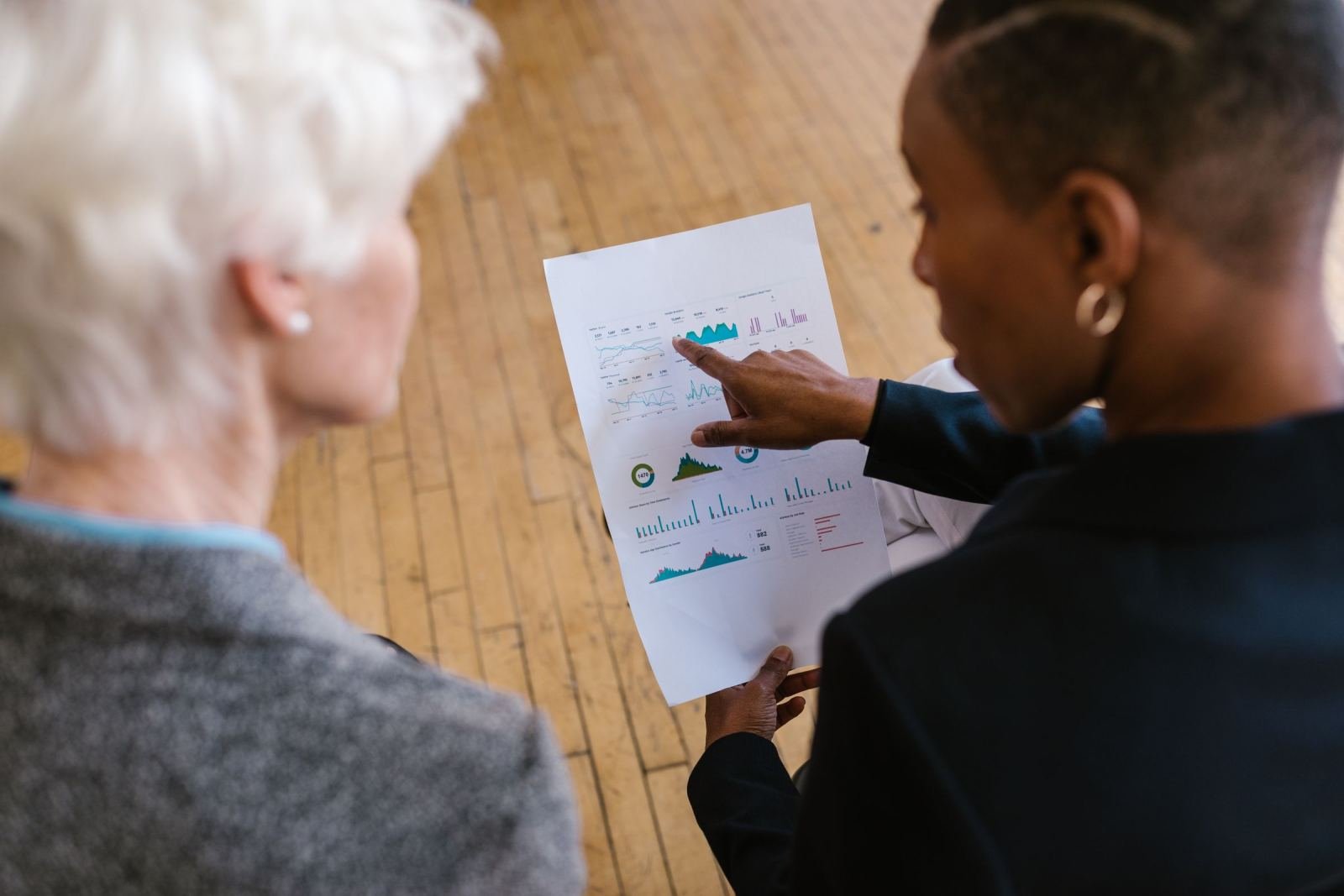 A counselor and a woman review a printed report with charts and graphs together