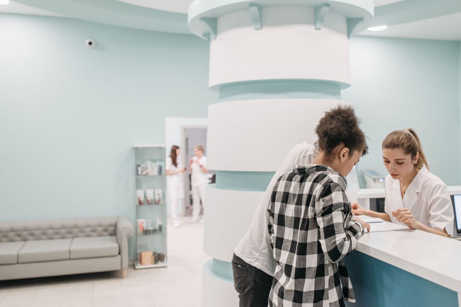 Staff meet two people at the front desk of a clinic
