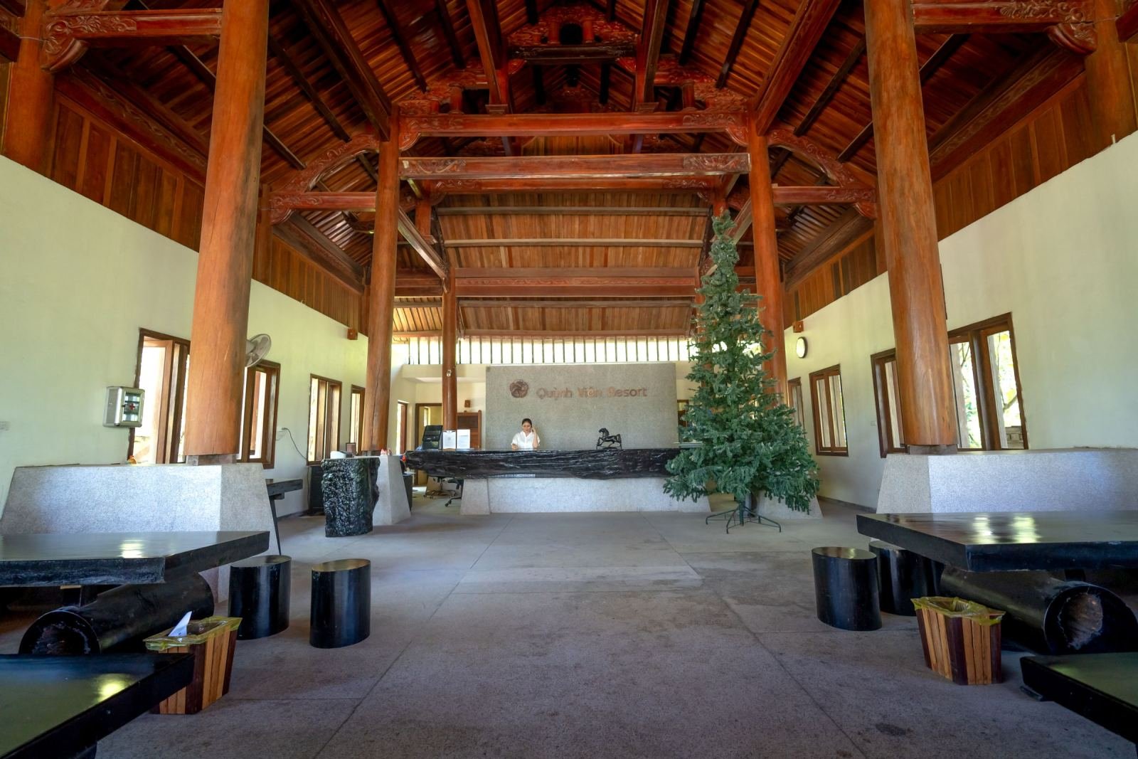 A spacious resort lobby with high wooden ceilings and a reception desk