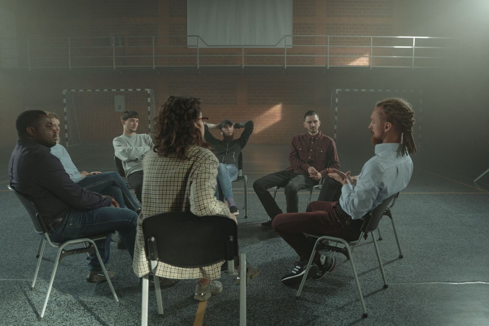 A group of people sitting in a circle of chairs for a group discussion