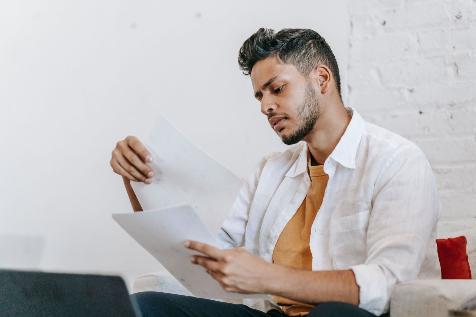 A man in a white shirt reviews printed documents