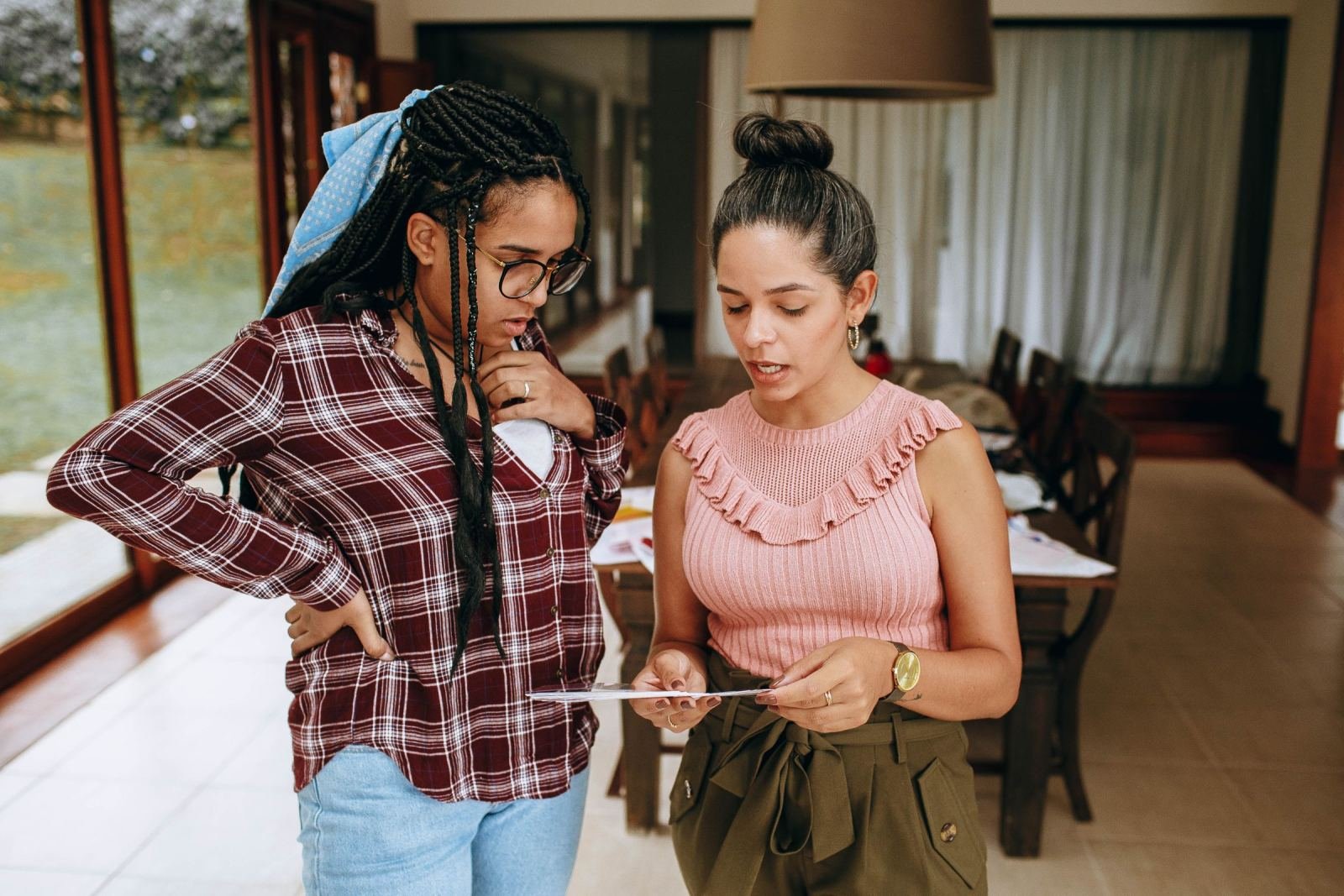 Two women look at a brochure together in a bright room