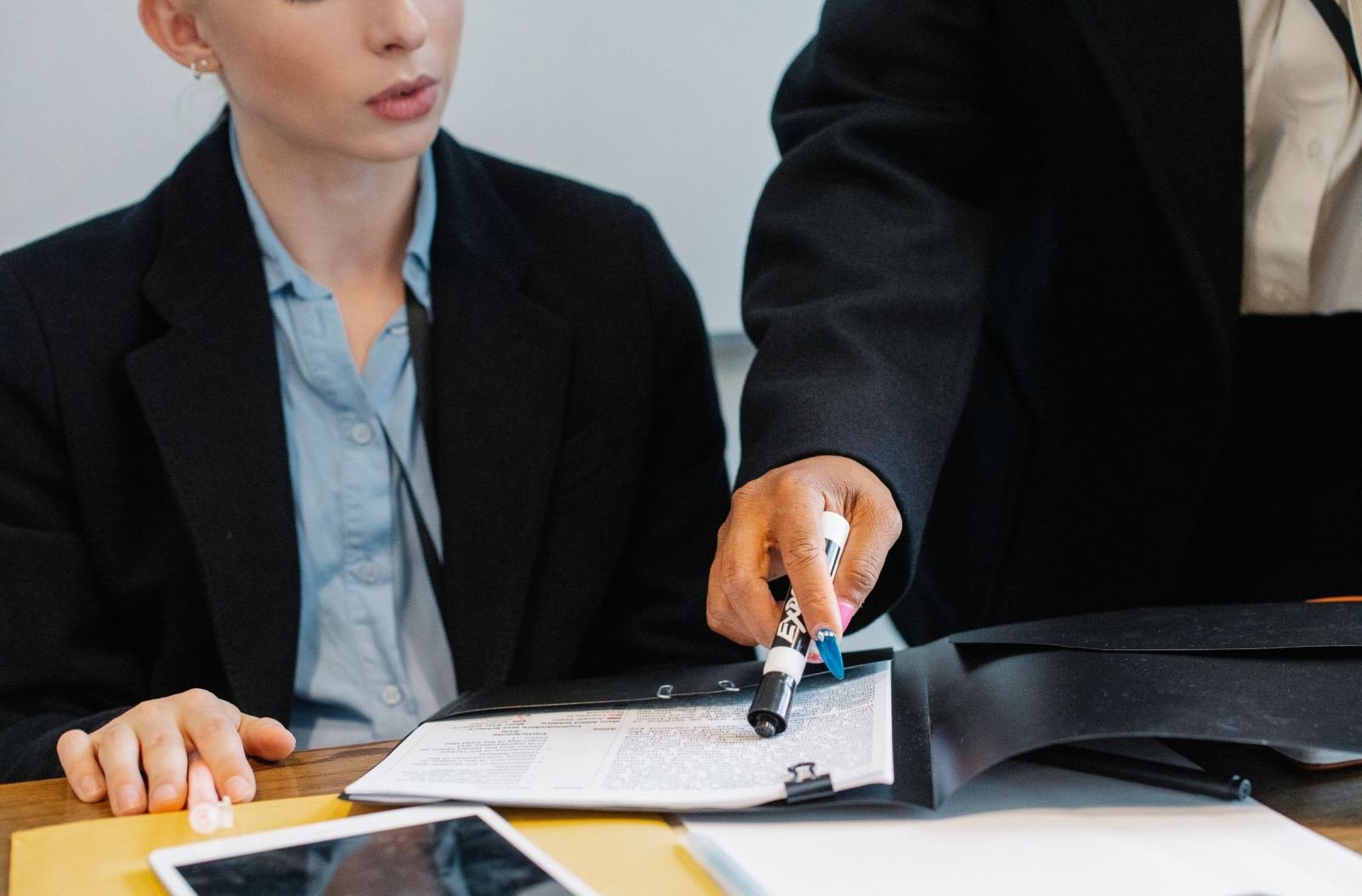 A clinic staff member points to a document while sitting with a client