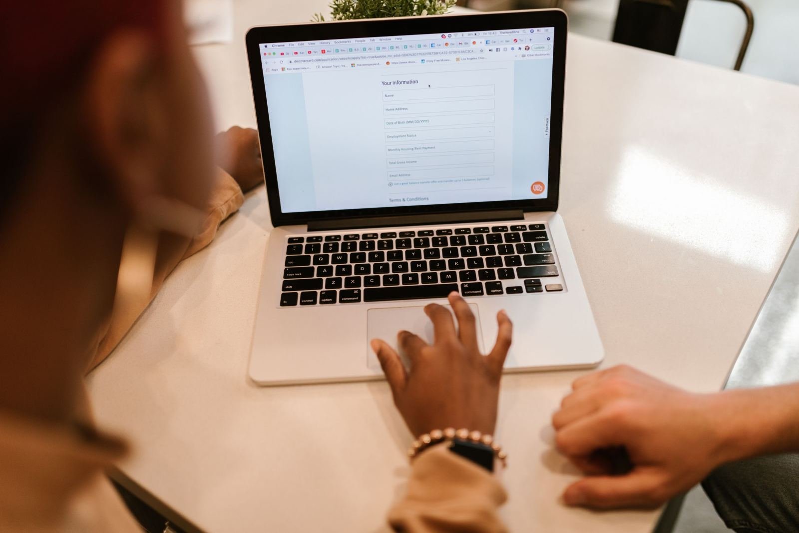 A person fills out an online application form on a laptop