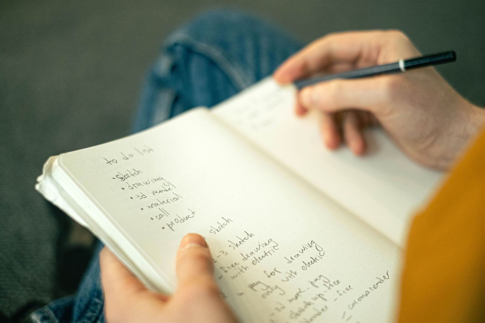 A person writing a to-do list in a notebook