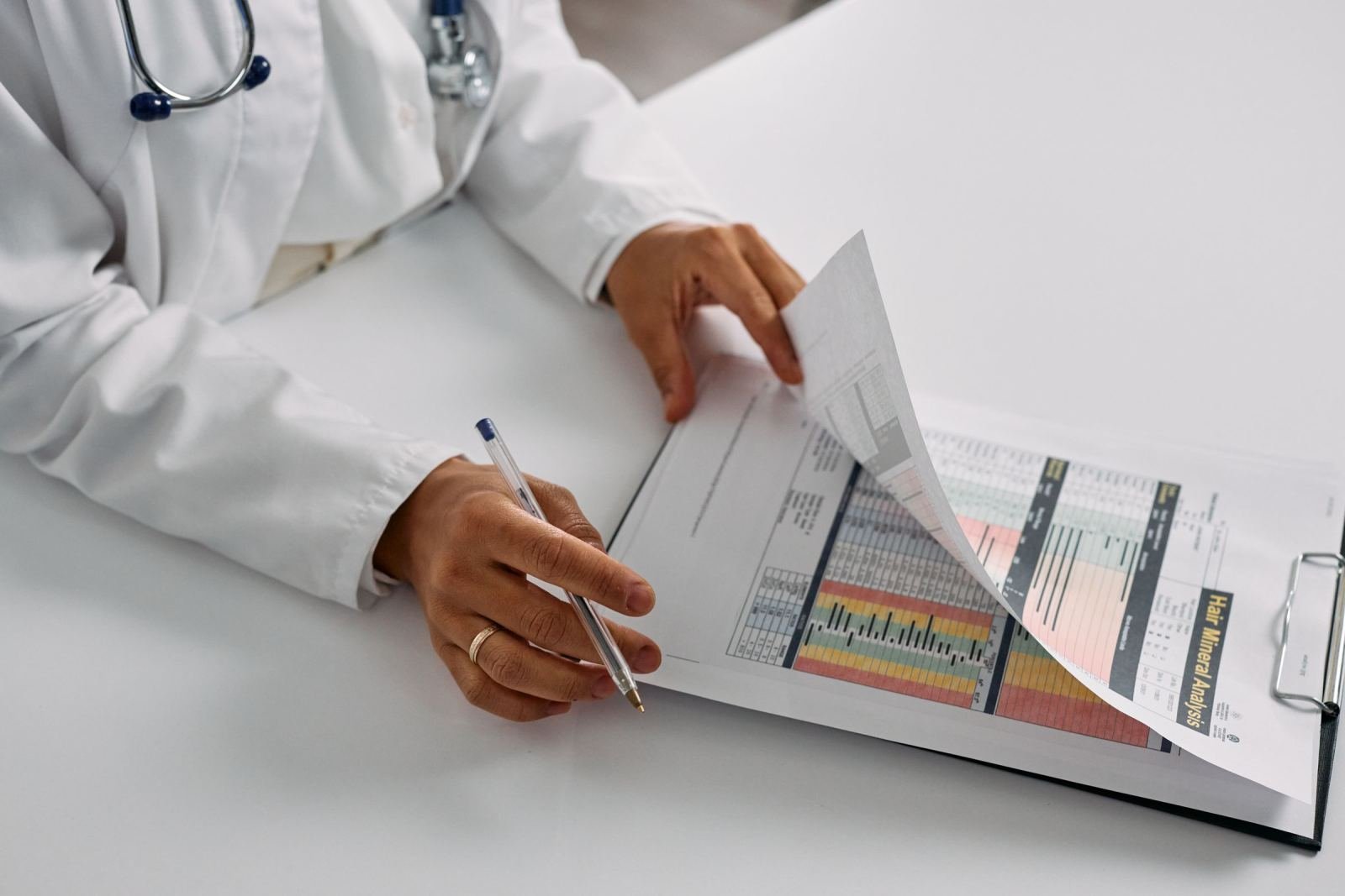 A healthcare provider in a white coat reviews a medical chart on a clipboard