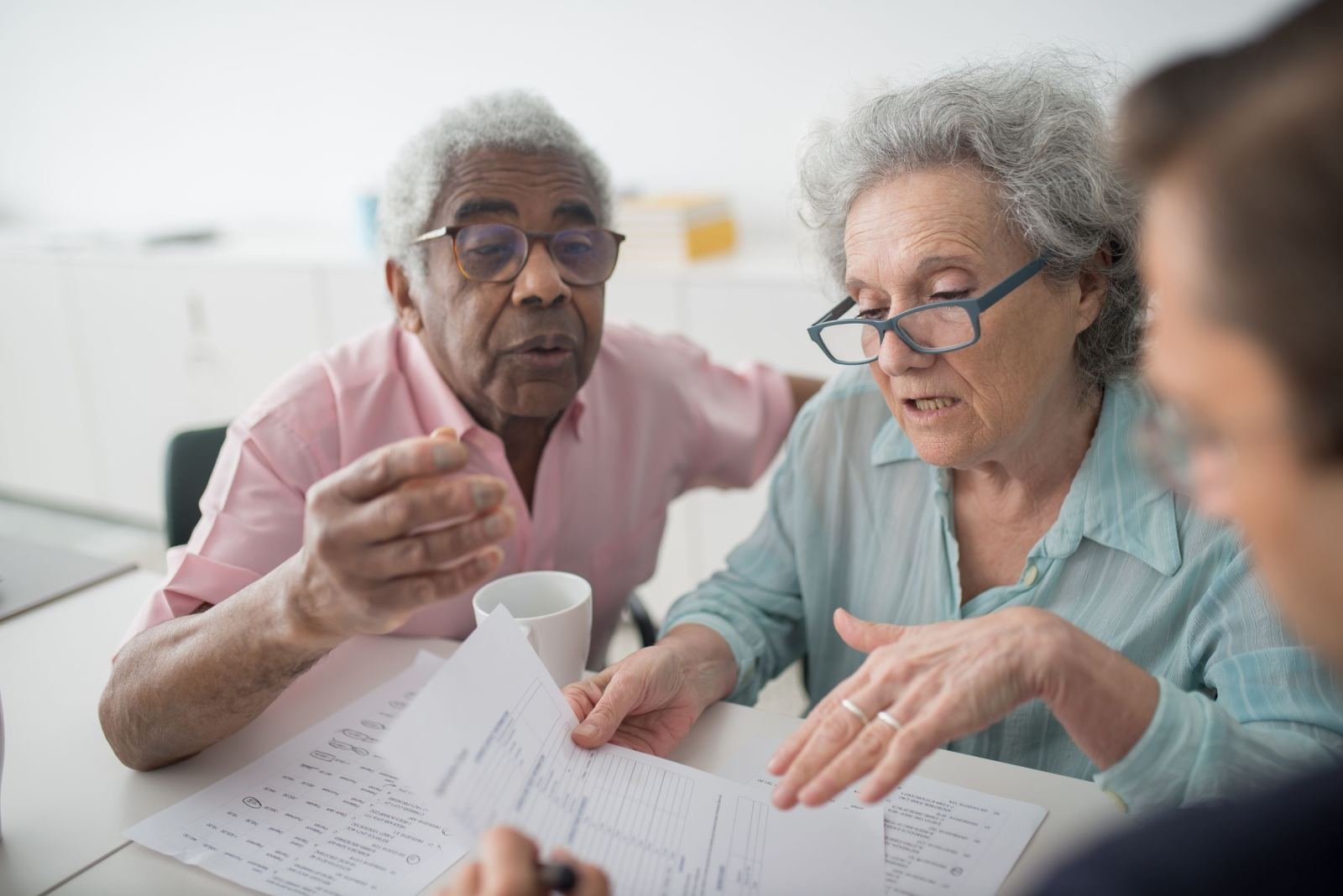 An older couple reviews paperwork with a counselor in a bright office