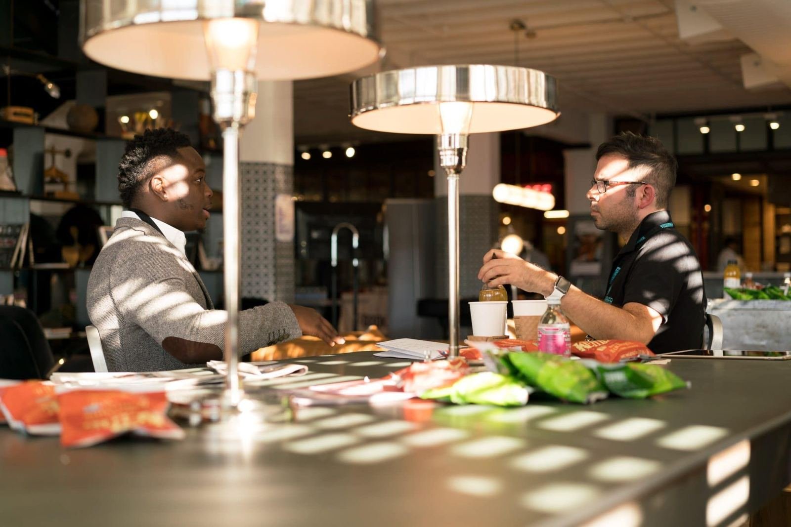 Two men in professional attire having a conversation at a table