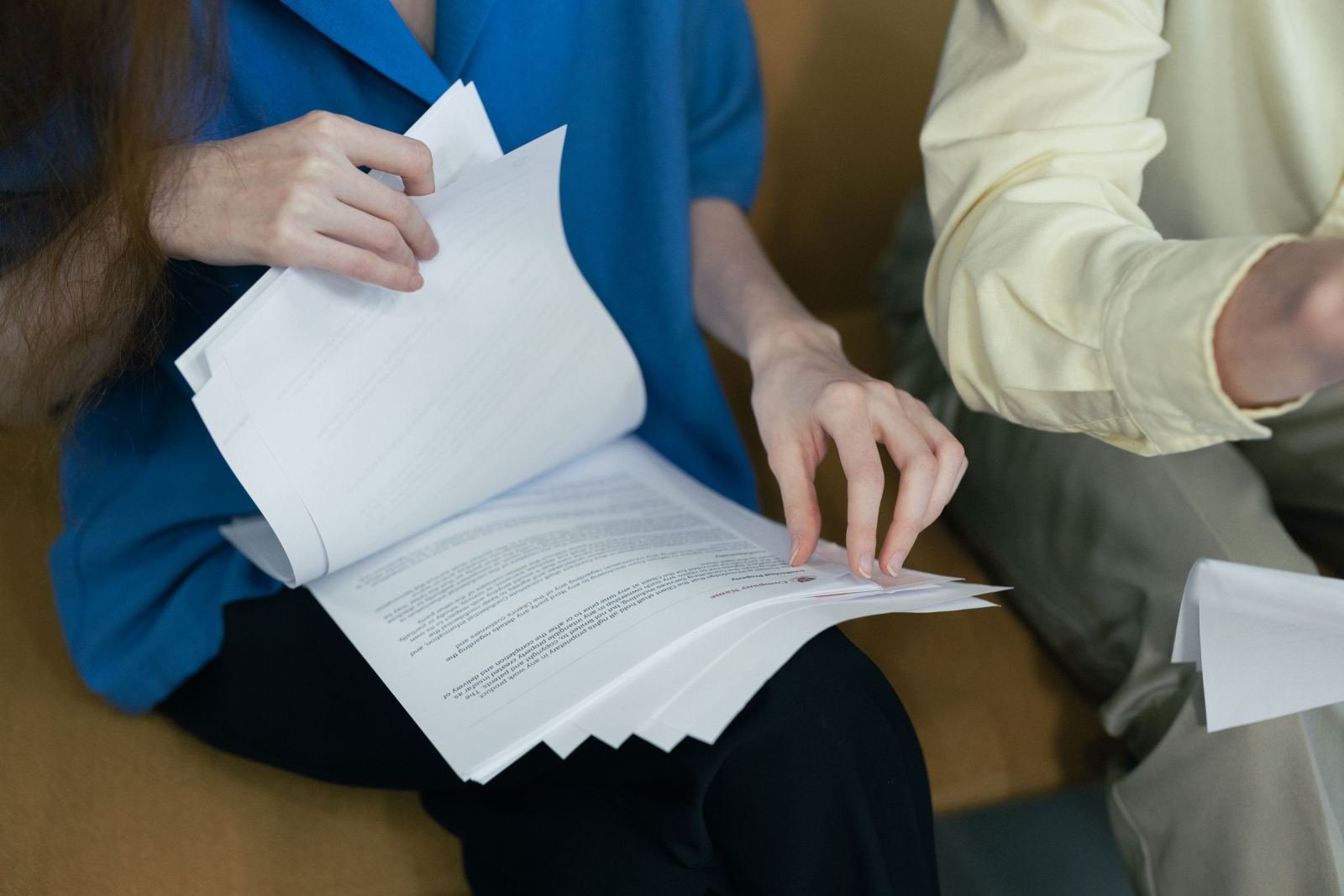 Two people review printed documents together